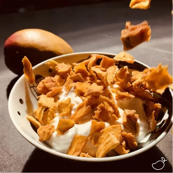Kleine stukjes gedroogde mango in de yoghurt